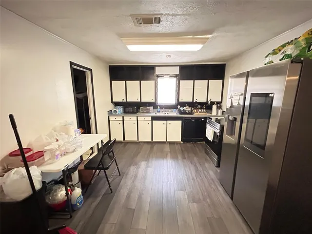 a kitchen with stainless steel appliances granite countertop hardwood floor sink stove dining table and chairs