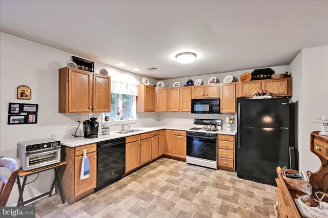 a kitchen with stainless steel appliances granite countertop a stove top oven a sink and dishwasher