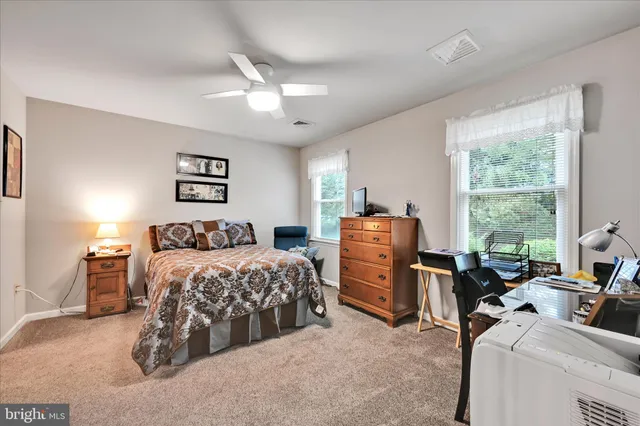 a bedroom with bed and large windows