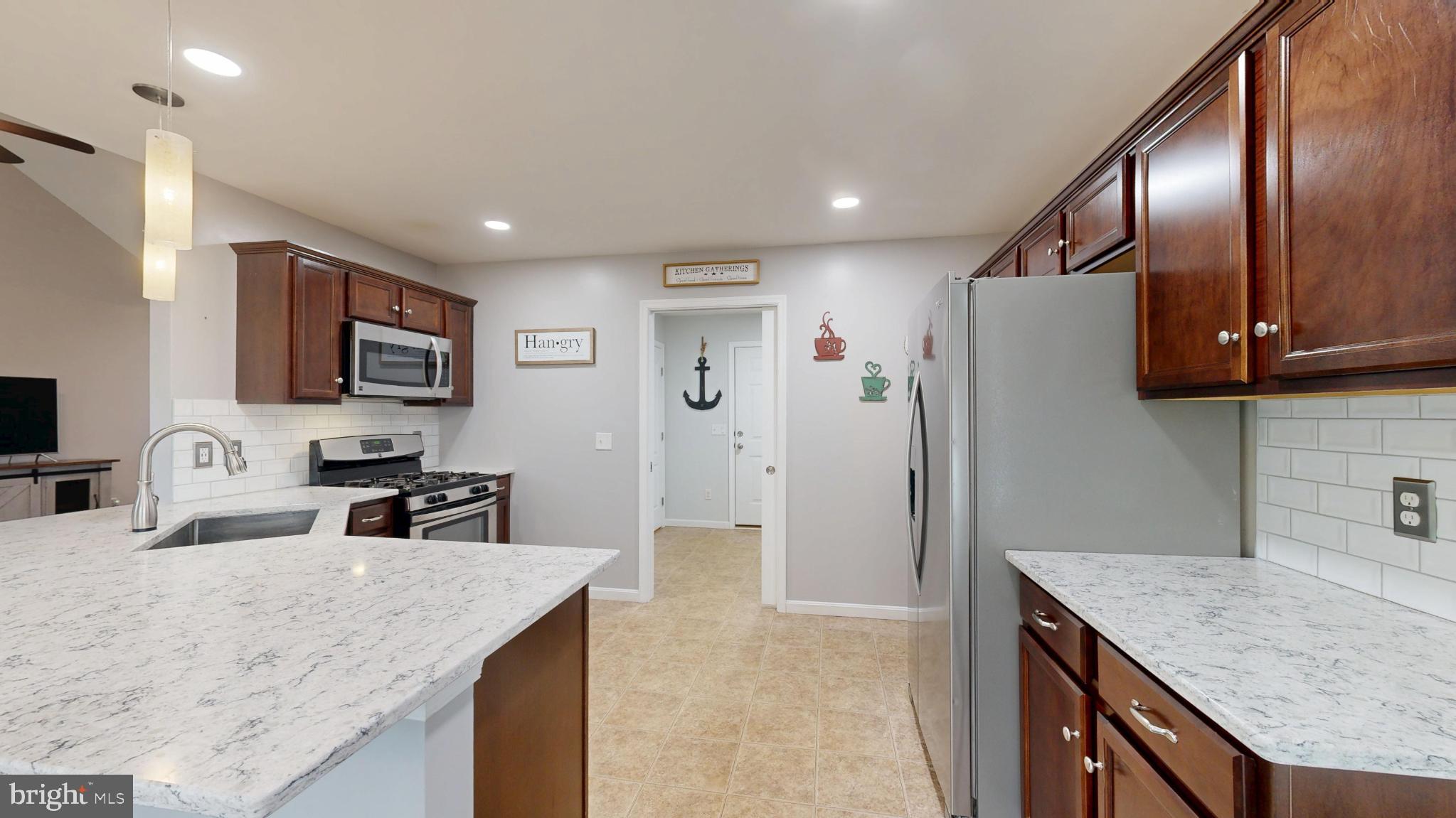 202 East Buck Point Road Clayton, DE 19938 - Photo 11 of 53 a kitchen with stainless steel appliances granite countertop a sink refrigerator and microwave