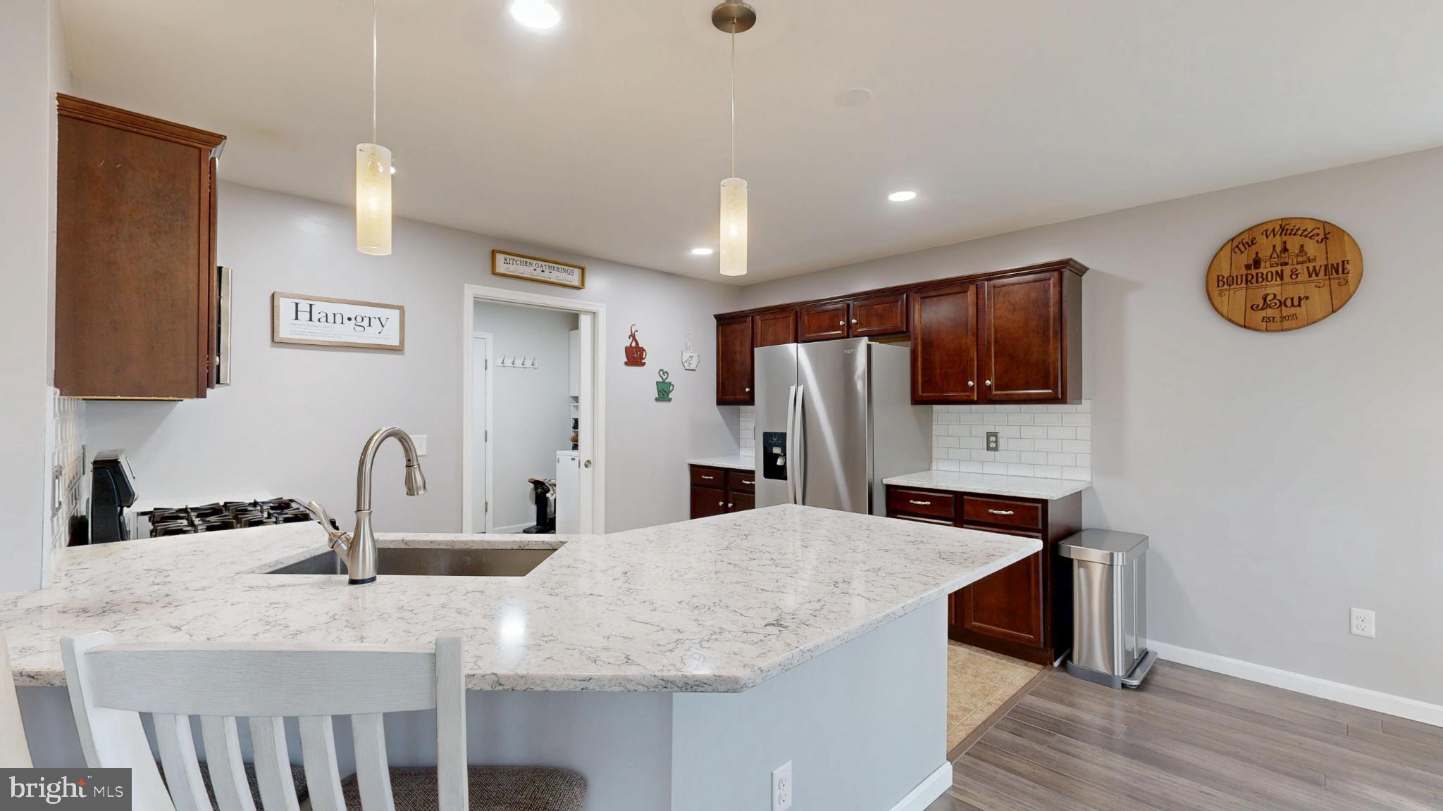 202 East Buck Point Road Clayton, DE 19938 - Photo 8 of 53 a kitchen with stainless steel appliances granite countertop a sink a microwave cabinets and wooden floor
