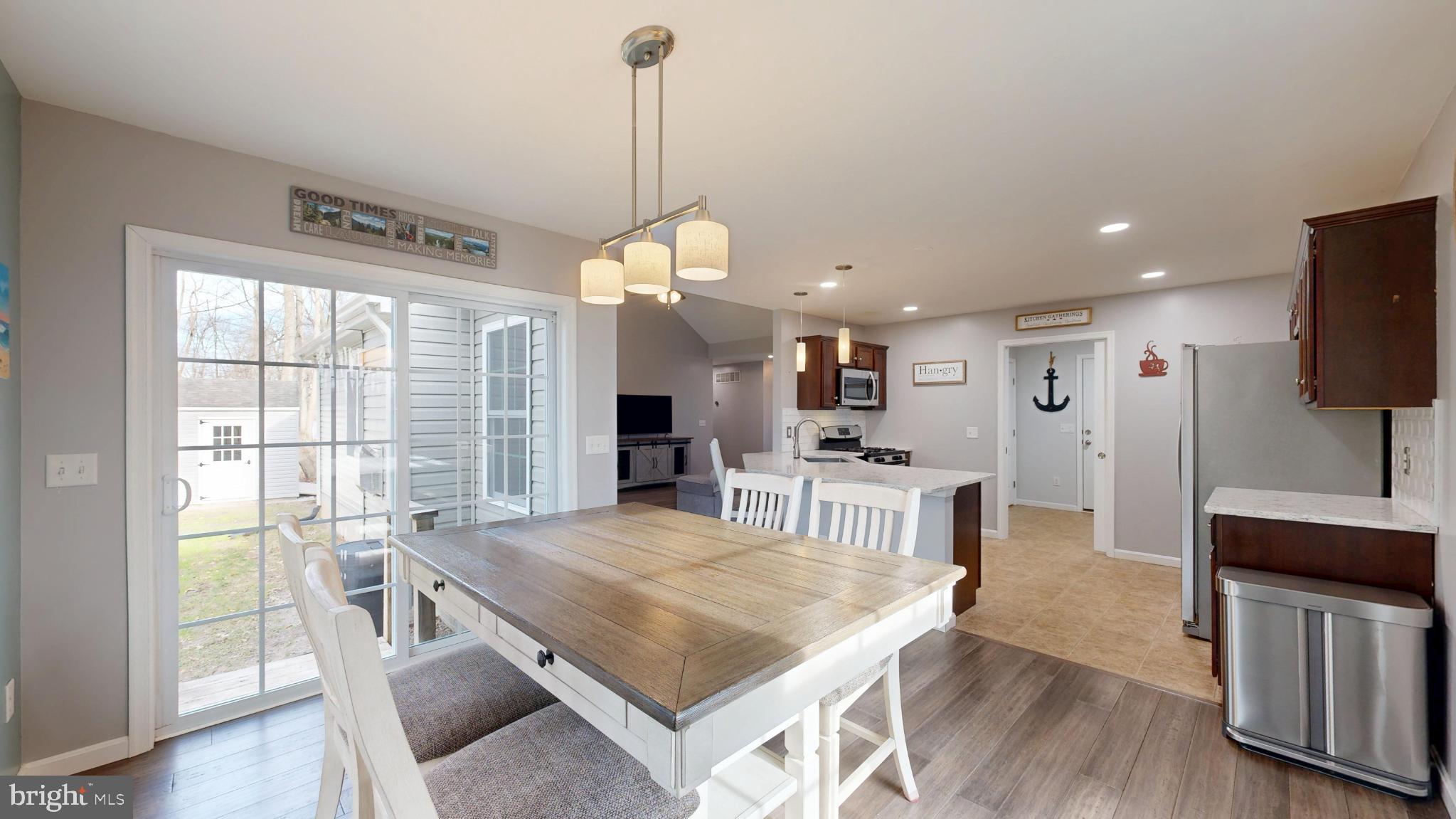 202 East Buck Point Road Clayton, DE 19938 - Photo 9 of 53 a open kitchen with stainless steel appliances granite countertop a stove oven and a dining table with wooden floor