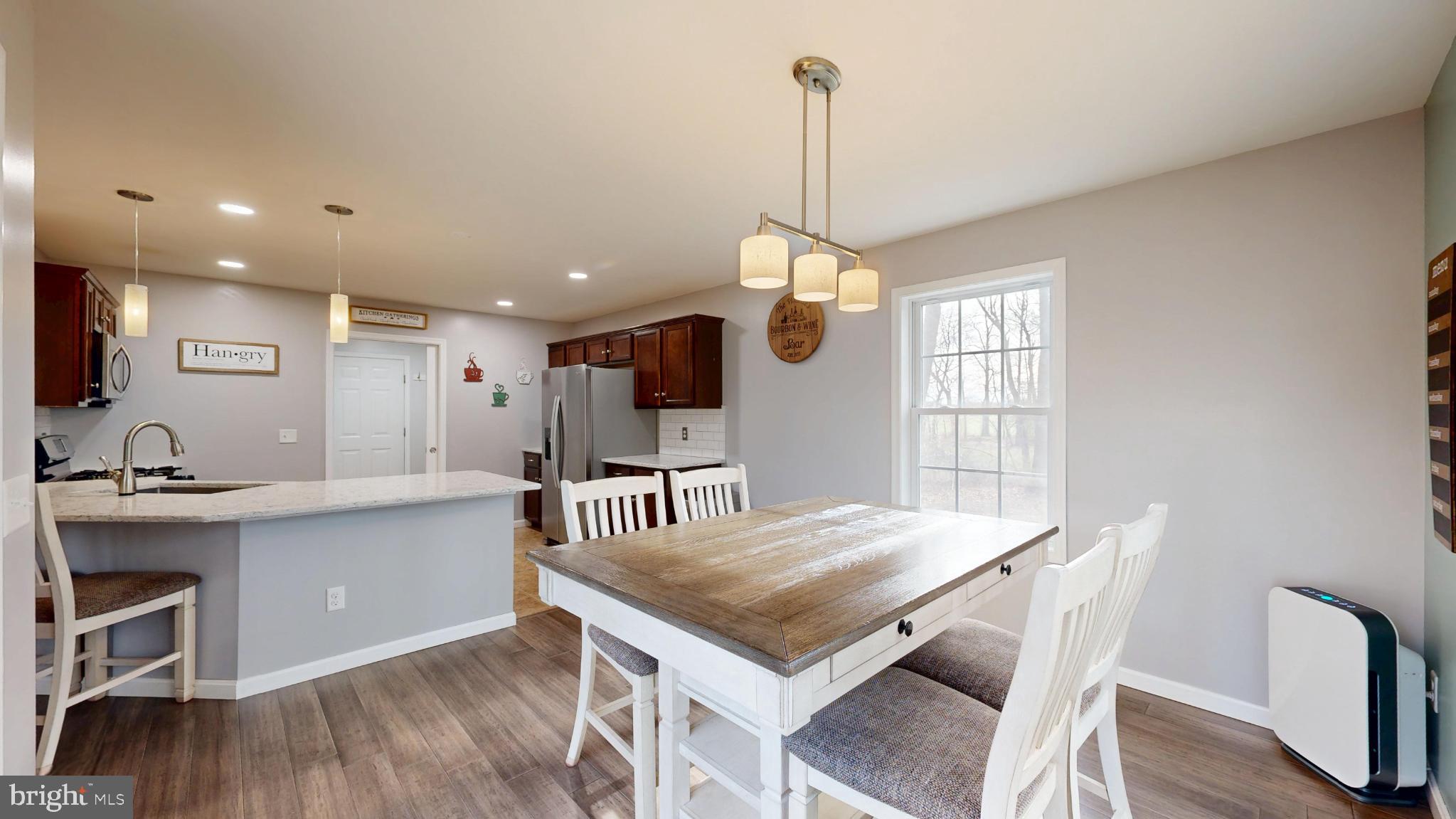202 East Buck Point Road Clayton, DE 19938 - Photo 10 of 53 a view of a dining room and livingroom with furniture wooden floor a chandelier