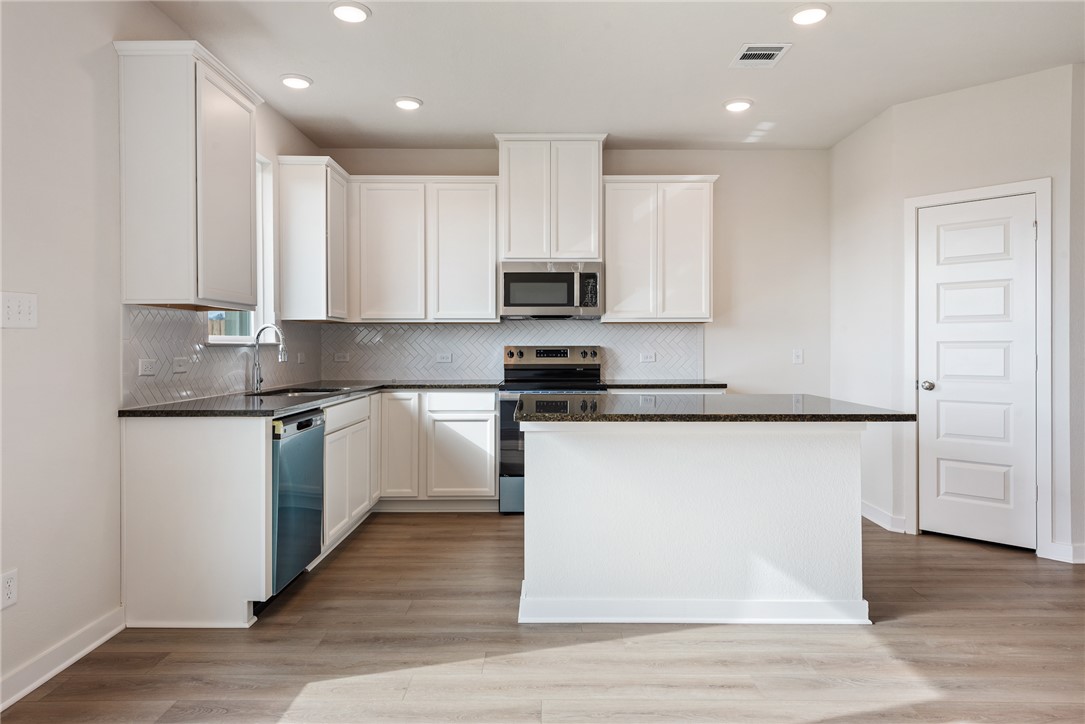 2415 Rooke Road Bryan, TX 77807 - Photo 20 of 36 a kitchen with granite countertop a refrigerator and a stove