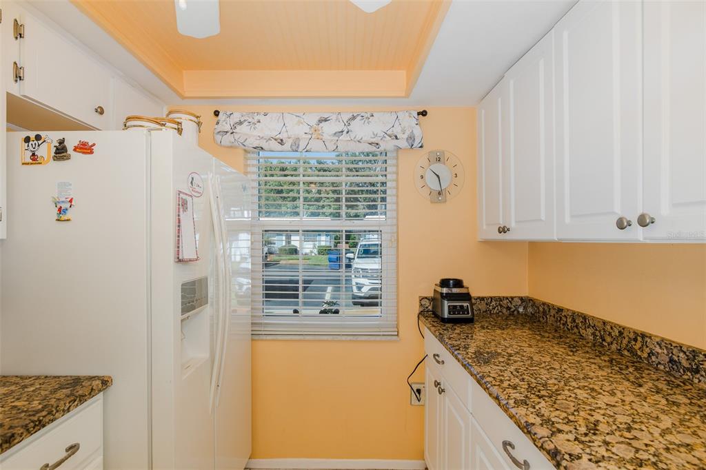 4206 Richmere Drive, Unit 3 New Port Richey, FL 34652 - Photo 11 of 41 a kitchen with granite countertop a sink and a refrigerator