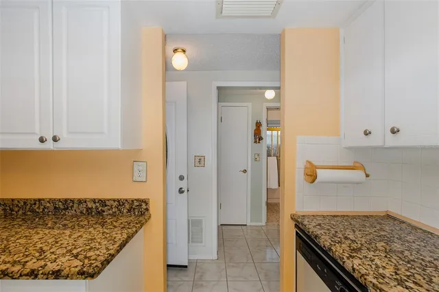a kitchen with granite countertop white cabinets and a stove