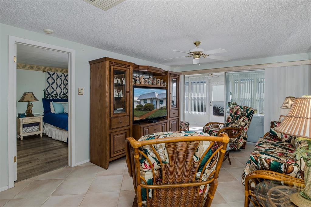 4206 Richmere Drive, Unit 3 New Port Richey, FL 34652 - Photo 17 of 41 a living room with furniture a flat screen tv and floor to ceiling window