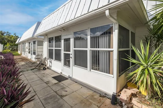 a view of a house with a potted plant and floor to ceiling window