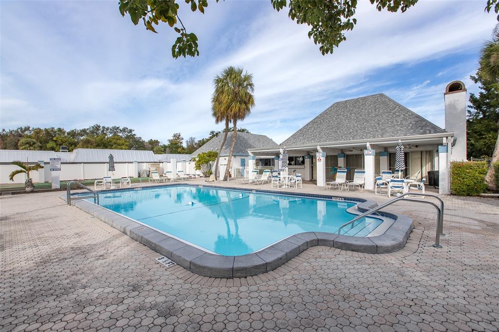 4206 Richmere Drive, Unit 3 New Port Richey, FL 34652 - Photo 39 of 41 a view of a house with pool and chairs