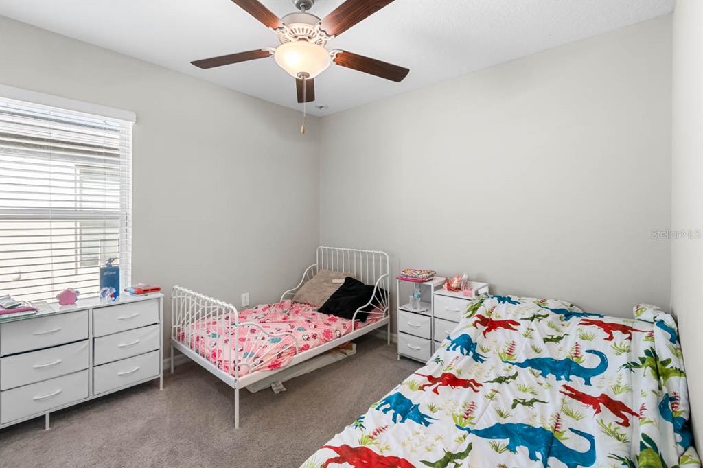 889 Calico Scallop Street Ruskin, FL 33570 - Photo 14 of 32 a bedroom with a bed and a dresser in it