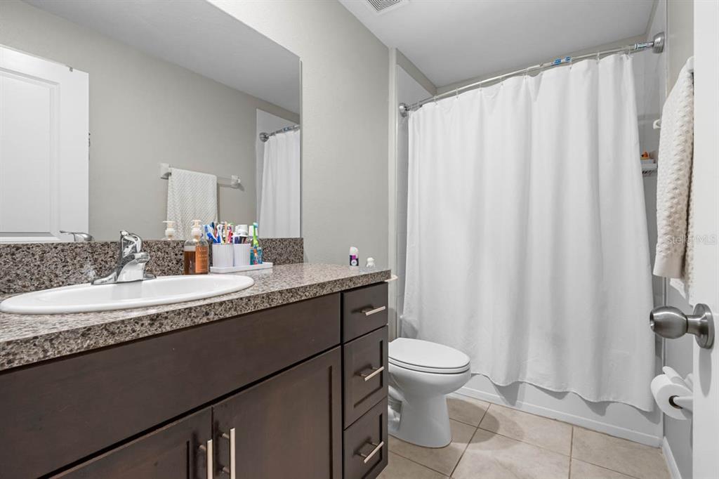 889 Calico Scallop Street Ruskin, FL 33570 - Photo 16 of 32 a bathroom with a granite countertop sink and a mirror