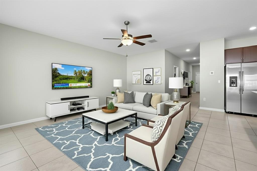 889 Calico Scallop Street Ruskin, FL 33570 - Photo 17 of 32 a living room with furniture a flat screen tv and a table