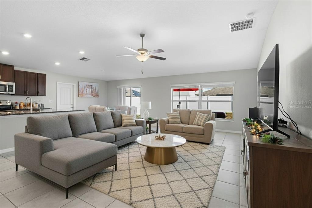 889 Calico Scallop Street Ruskin, FL 33570 - Photo 2 of 32 a living room with furniture a fireplace and a flat screen tv