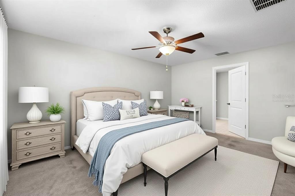889 Calico Scallop Street Ruskin, FL 33570 - Photo 9 of 32 a bedroom with a bed and a chandelier