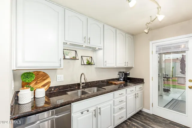 a kitchen with stainless steel appliances granite countertop a sink a stove and cabinets