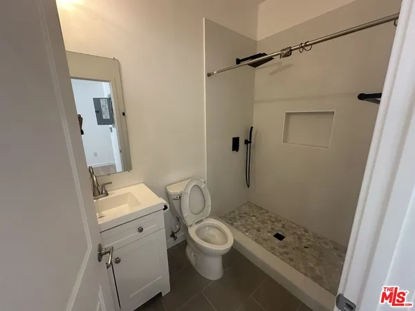 a bathroom with a granite countertop sink toilet and shower