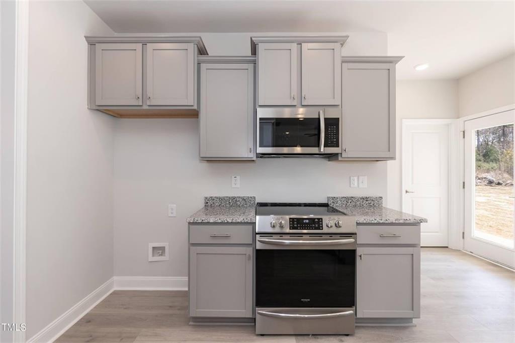 654 Bald Ridge Circle Demorest, GA 30535 - Photo 6 of 22 a kitchen with stainless steel appliances granite countertop a stove a microwave and a sink