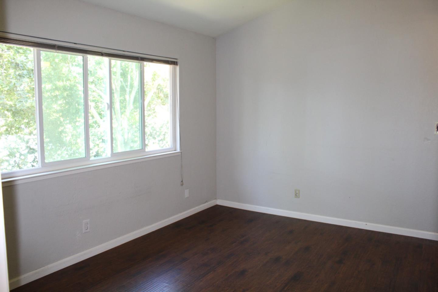 1025 Fillippelli Drive Gilroy, CA 95020 - Photo 23 of 47 an empty room with wooden floor and windows