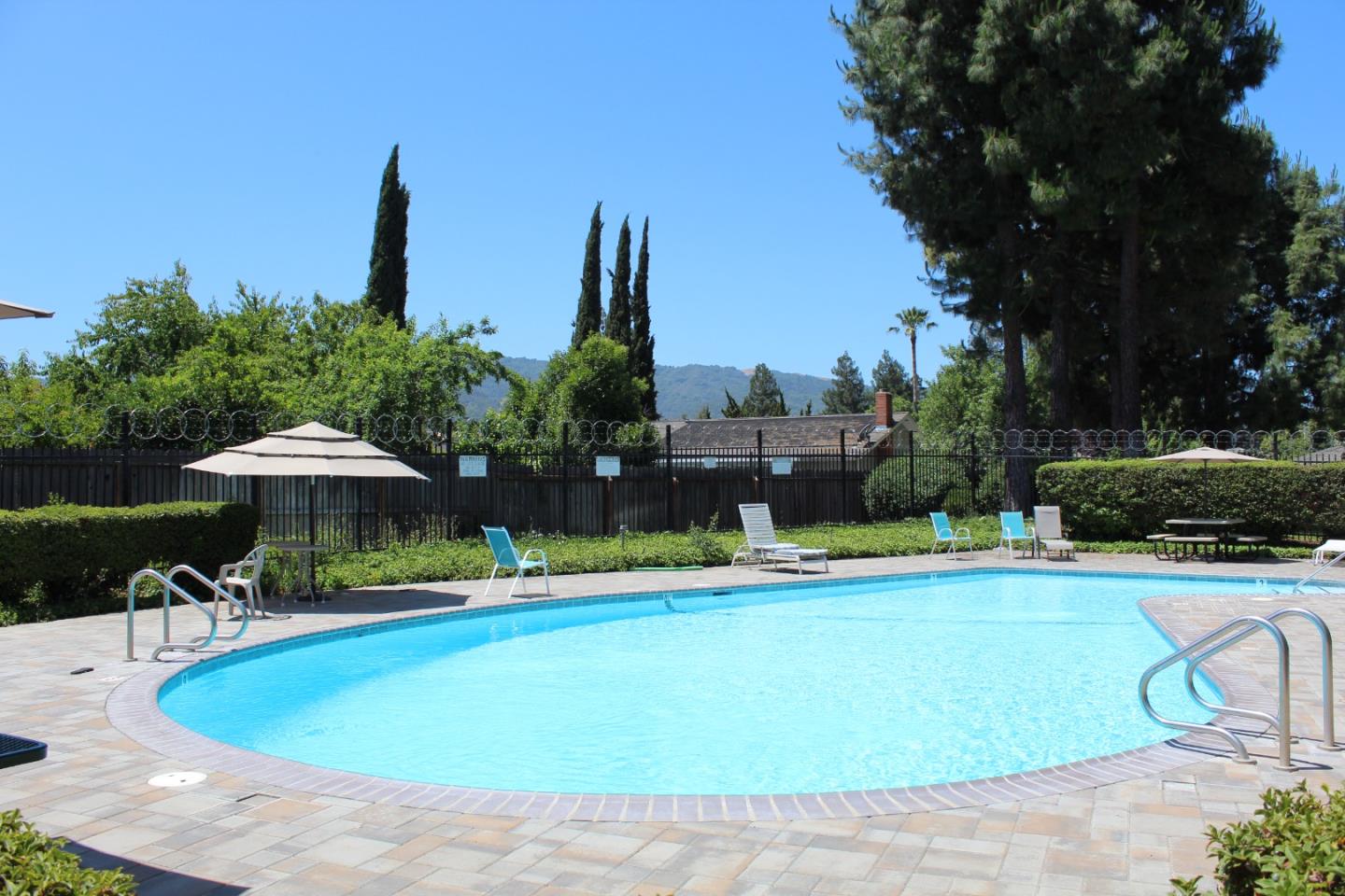 1025 Fillippelli Drive Gilroy, CA 95020 - Photo 42 of 47 a view of a swimming pool with lawn chairs under an umbrella