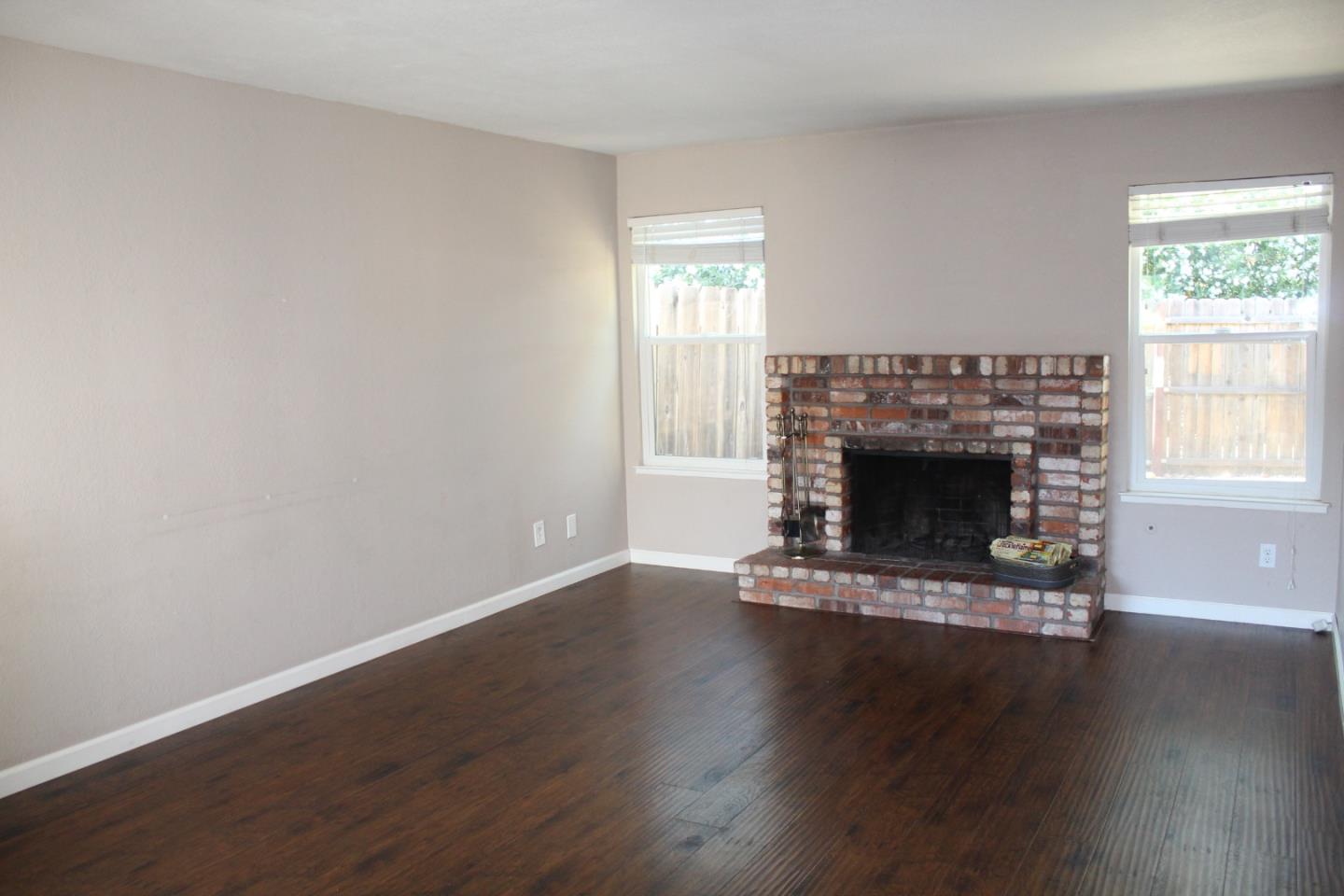 1025 Fillippelli Drive Gilroy, CA 95020 - Photo 6 of 47 a view of a livingroom with a fireplace wooden floor and windows