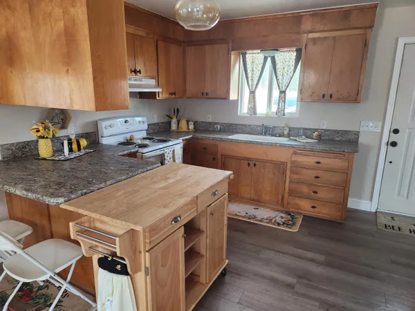 a kitchen with appliances cabinets and wooden floor
