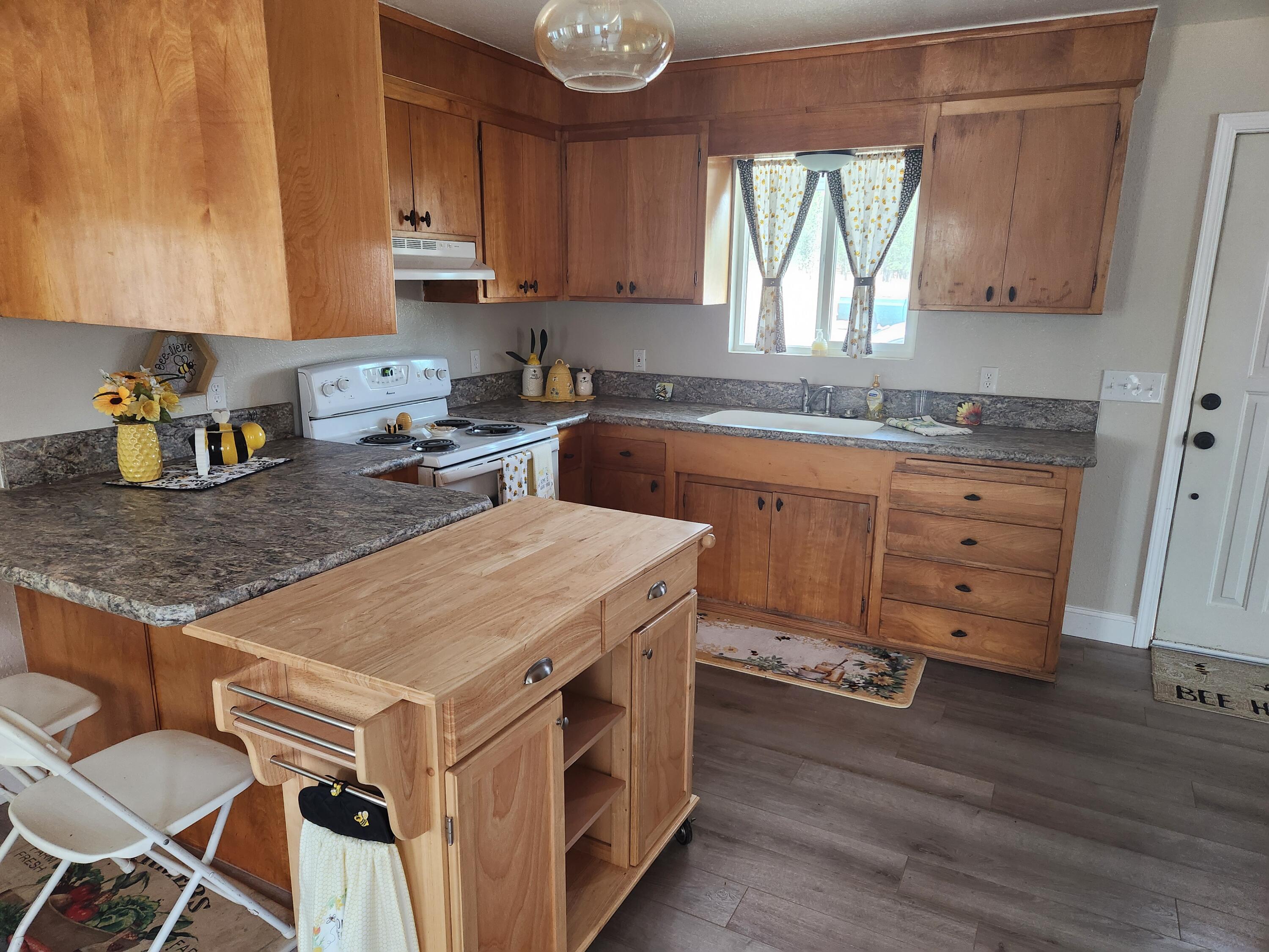 24327 Bascom Road Millville, CA 96062 - Photo 4 of 13 a kitchen with appliances cabinets and wooden floor