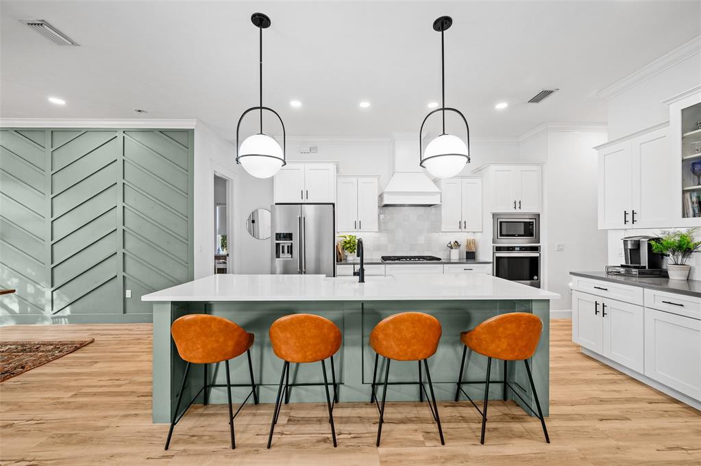 1068 Southwest 120th Drive Gainesville, FL 32607 - Photo 13 of 43 a kitchen with cabinets a sink dining table and chairs