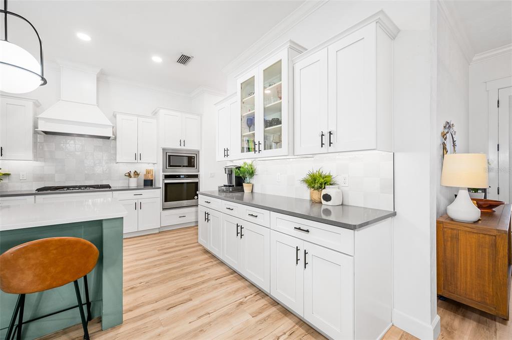 1068 Southwest 120th Drive Gainesville, FL 32607 - Photo 16 of 43 a kitchen with white cabinets and wooden floor