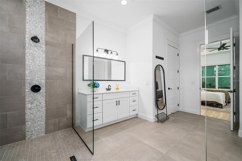 1068 Southwest 120th Drive Gainesville, FL 32607 - Photo 25 of 43 a bathroom with a double vanity sink a mirror a window and a shower