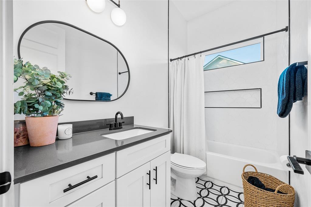 1068 Southwest 120th Drive Gainesville, FL 32607 - Photo 30 of 43 a bathroom with a granite countertop sink a toilet and a mirror