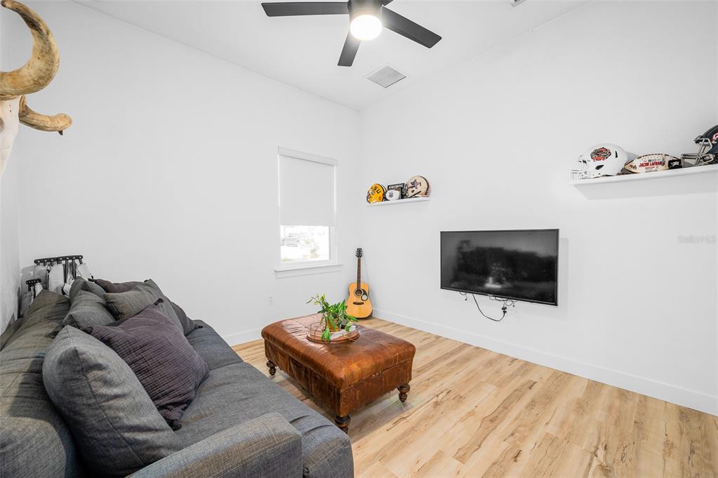1068 Southwest 120th Drive Gainesville, FL 32607 - Photo 31 of 43 a living room with furniture and a flat screen tv