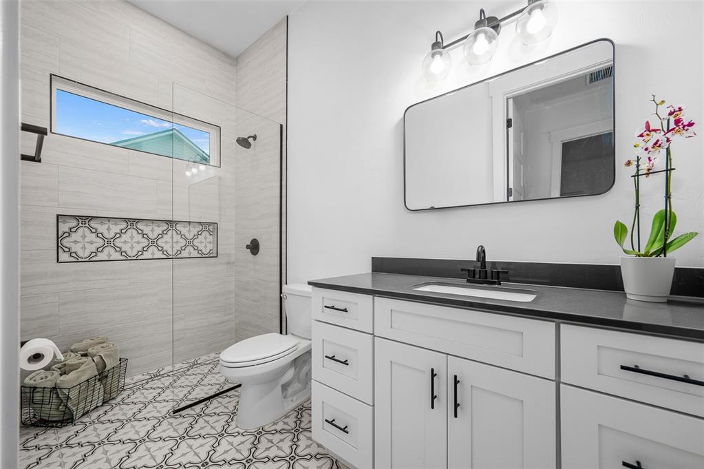 1068 Southwest 120th Drive Gainesville, FL 32607 - Photo 33 of 43 a bathroom with a granite countertop sink a toilet and mirror