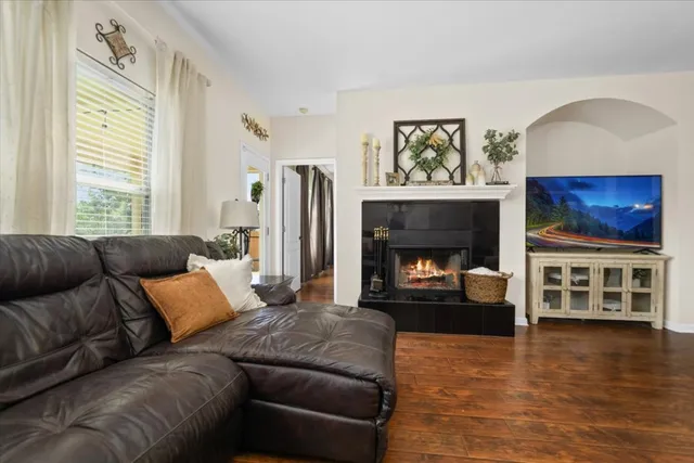 a living room with furniture a fireplace and a flat screen tv