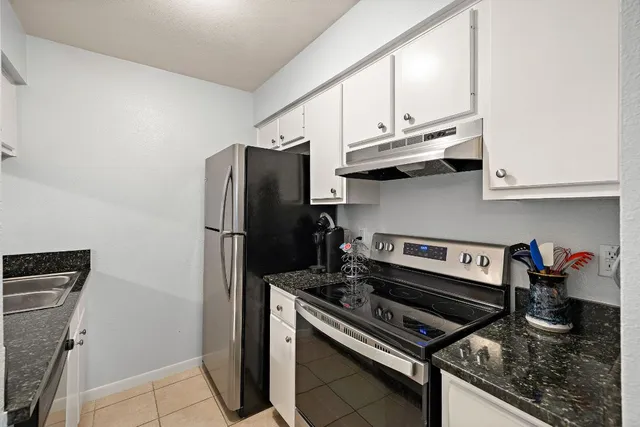 a kitchen with stainless steel appliances granite countertop a stove and a refrigerator