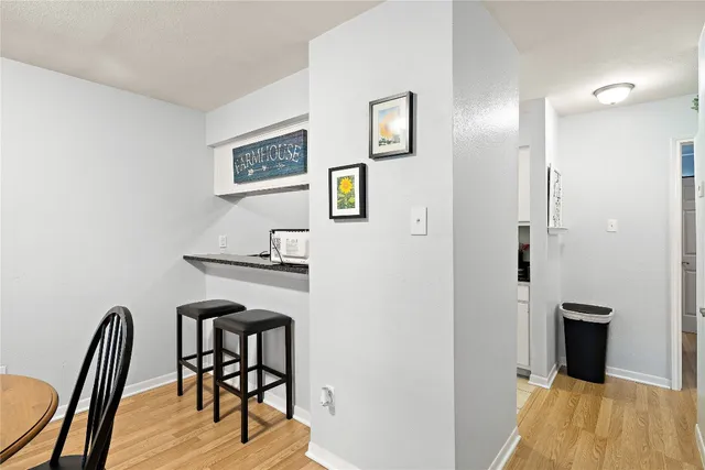a view of a workspace room with wooden floor and furniture