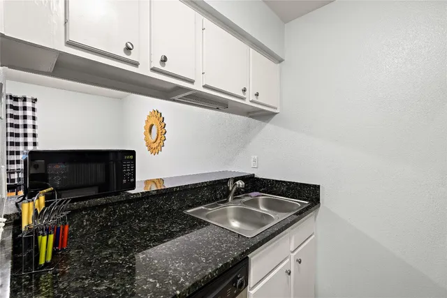 a kitchen with stainless steel appliances granite countertop a sink a stove and a microwave