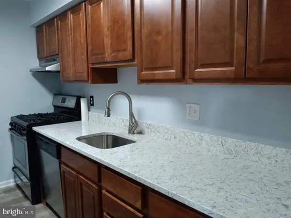 a kitchen with granite countertop a sink and cabinets