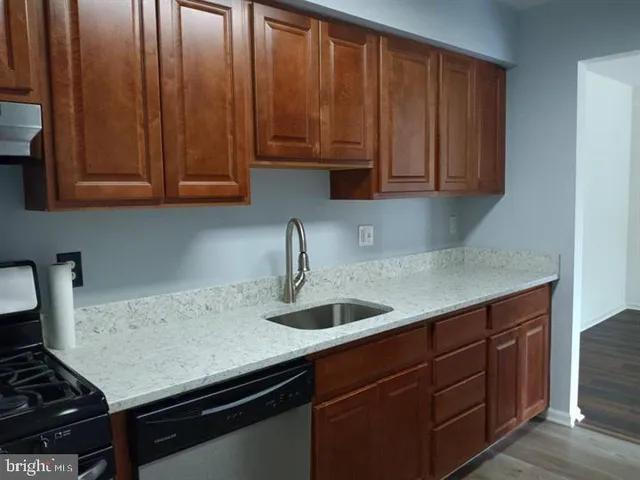 a kitchen with granite countertop a sink cabinets and stove