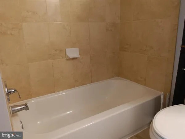 a bathroom with a white bath tub and toilet
