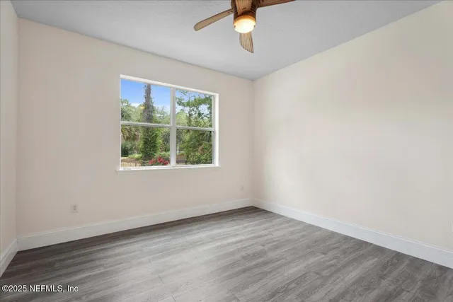 a view of an empty room with a chandelier fan