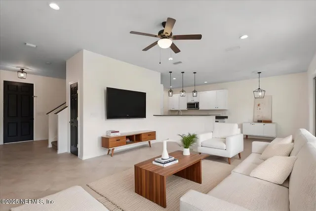 a living room with furniture kitchen view and a flat screen tv