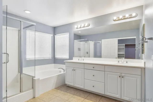 a spacious bathroom with a double vanity sink a mirror and a bathtub