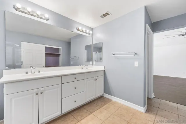 a bathroom with a double vanity sink and a mirror