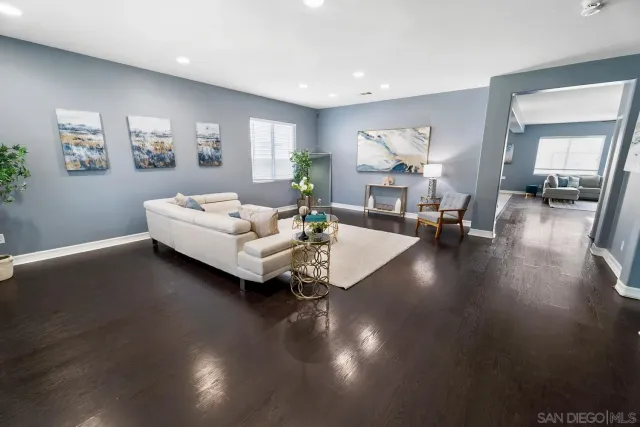 a living room with couches and a large mirror with wooden floor