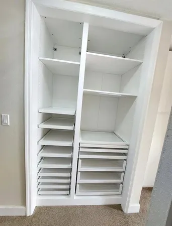 a view of walk in closet with empty racks