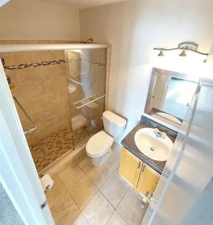 a bathroom with a granite countertop sink a toilet and bathtub