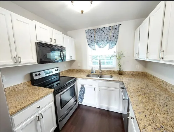 a kitchen with stainless steel appliances granite countertop a sink stove and microwave