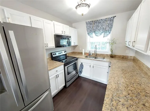 a kitchen with white cabinets and white appliances