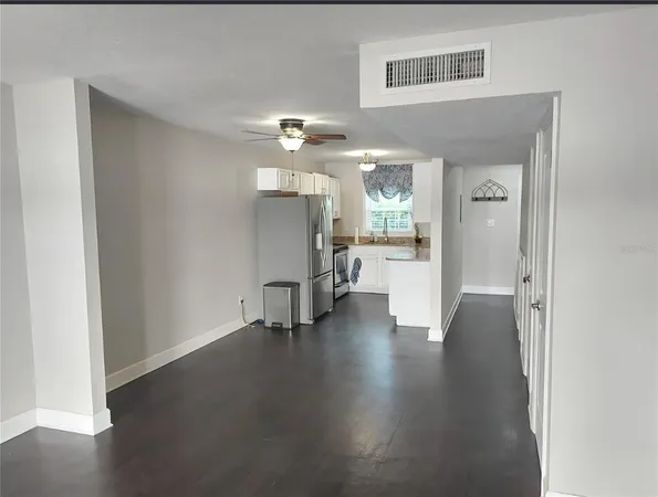 a view of a hallway with wooden floor a glass table and chairs