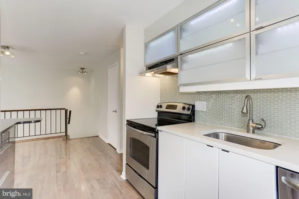 a kitchen with granite countertop a sink a stove and refrigerator